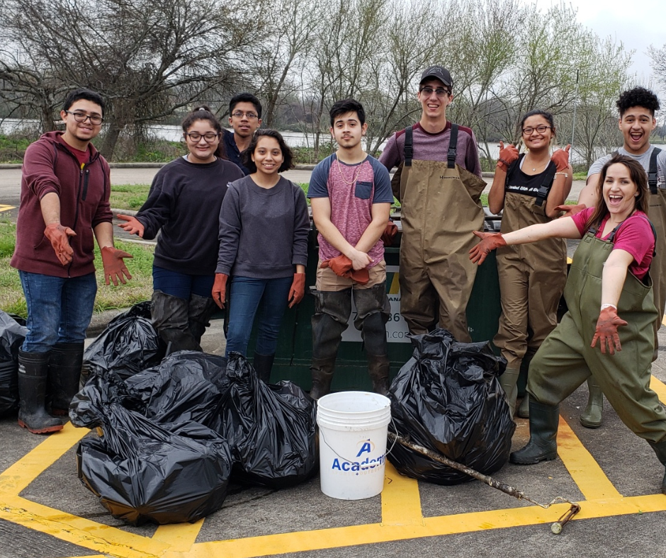 People standing in front of collected bags of trash