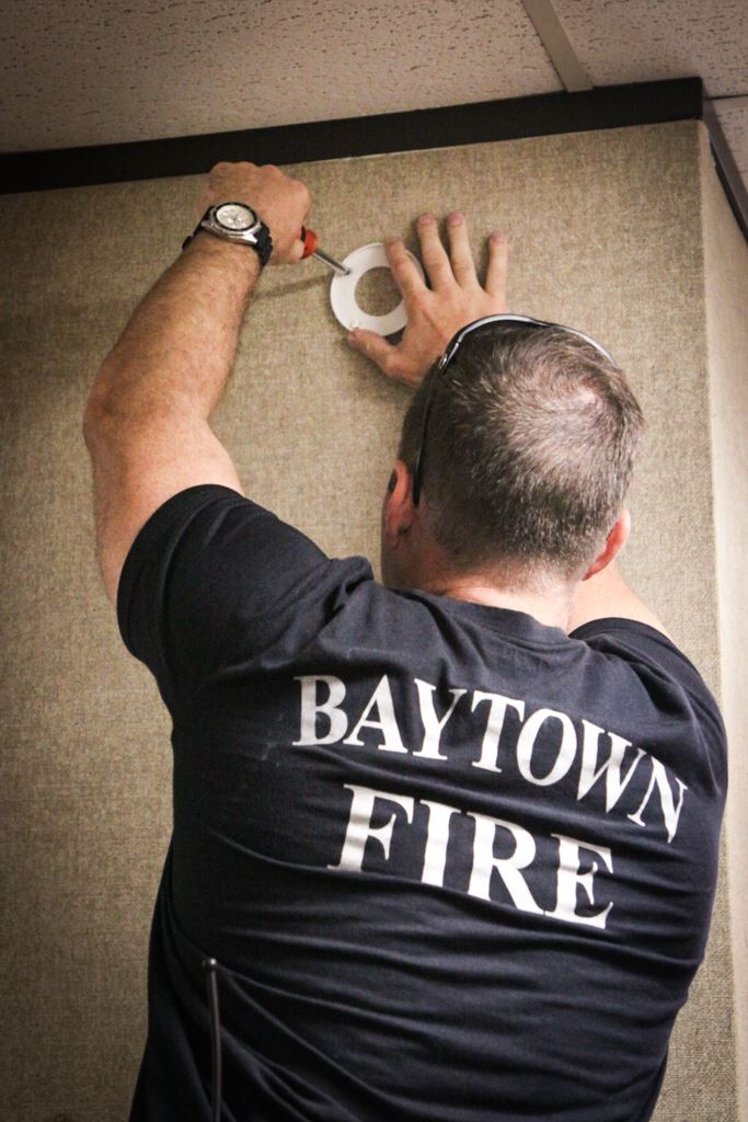 Fire Fighter replacing smoke detector battery