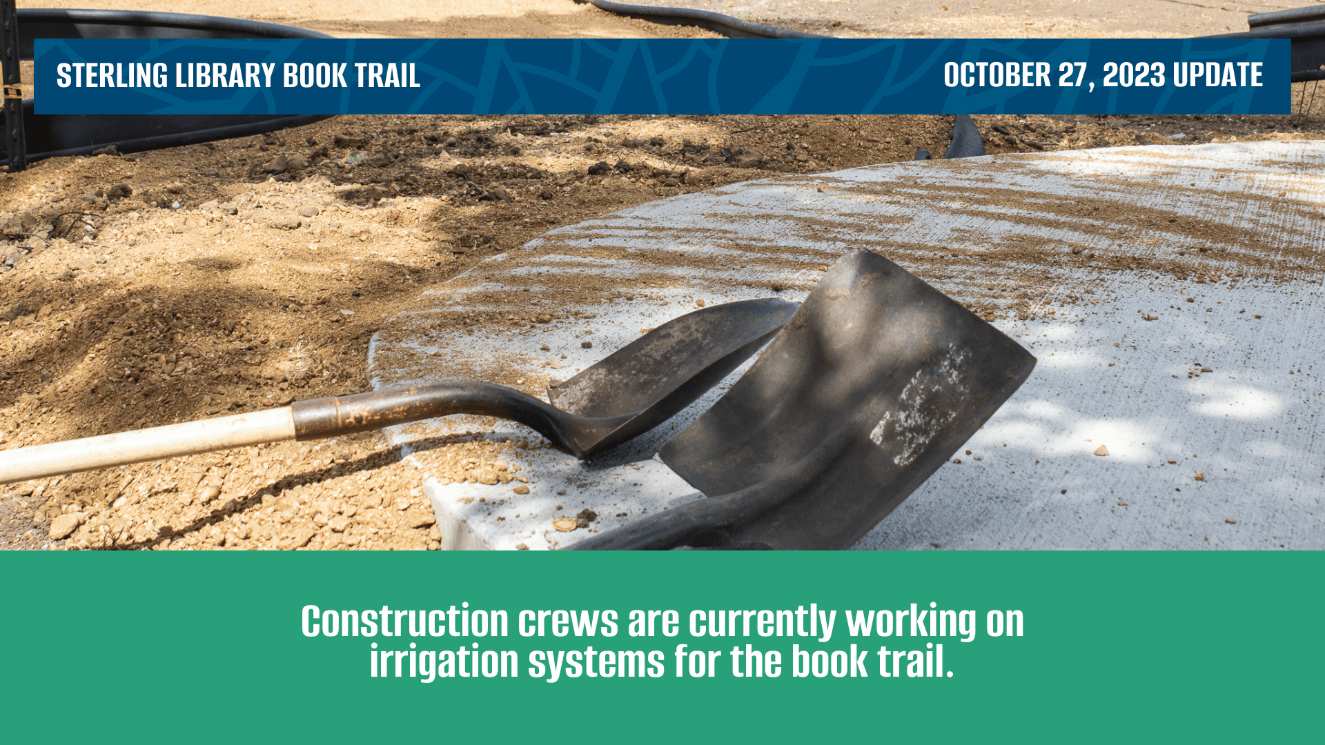 Two shovels laying on top of cement. A granite path nearby is being set for the new book trail.