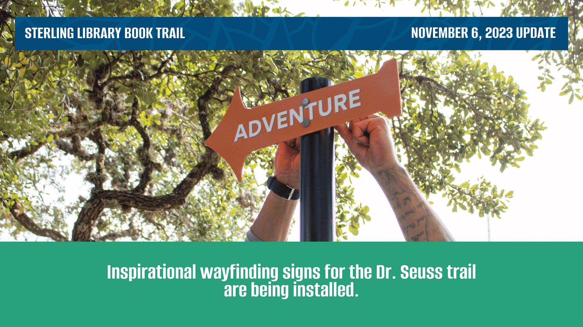 Two hands reach behind an orange wayfinding sign to fix it in place. sign reads "ADVENTURE"